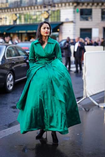 PARIS, FRANCE - MAY 08: A guest wears a green oversized silky dress, red liptsick, outside the Opera Garnier 350th Anniversary Gala in Paris on May 08, 2019 in Paris, France. (Photo by Edward Berthelot/Getty Images)