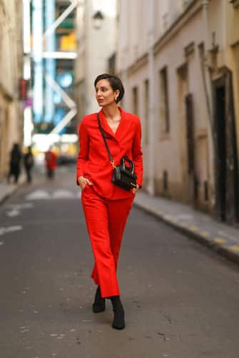 PARIS, FRANCE - FEBRUARY 23: Adriana Seminario wears a red blazer jacket from Sandro, red suit pants from Sandro, a black leather Jacquemus bag, black kitten heels suede pointy shoes, on February 23, 2021 in Paris, France. (Photo by Edward Berthelot/Getty Images)