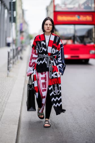 BERLIN, GERMANY - JULY 13: Maria Barteczko is seen wearing a patchwork knit coat Stella McCartney, black skinny jeans Acne Studios, black studded sandals Givenchy, black logo shopping tote bag Balenciaga, retro glasses Ray Ban on July 13, 2018 in Berlin, Germany. (Photo by Christian Vierig/Getty Images)