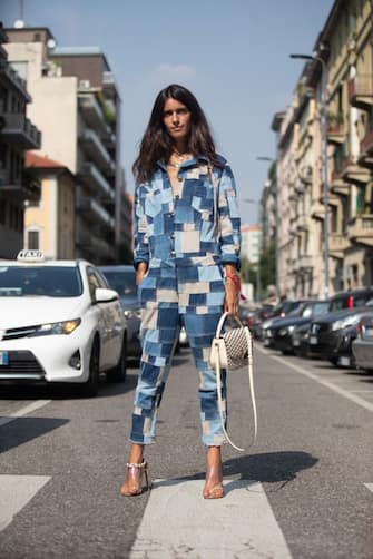 MILAN, ITALY - SEPTEMBER 21: Chiara Totire at Etro in a blue  denim patchwork jumpsuit, white purse, clear heels  during Milan Fashion Week Spring/Summer 2019 on September 21, 2018 in Milan, Italy.