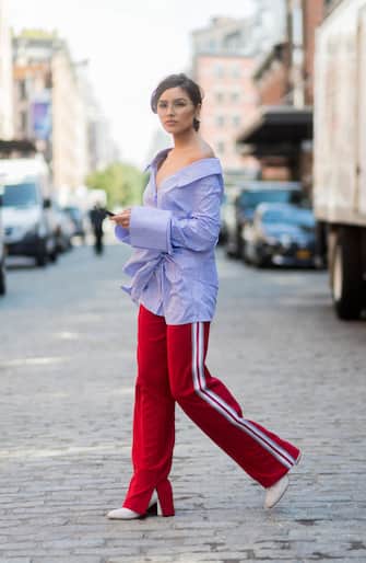 NEW YORK, NY - SEPTEMBER 07: Olivia Culpo is seen wearing a blue white striped button shirt with long sleeves Off White, red pants Anderson bell, white boots Stuart Weitzman, glasses Chloe in the streets of Manhattan during New York Fashion Week on September 7, 2017 in New York City (Photo by Christian Vierig/Getty Images)