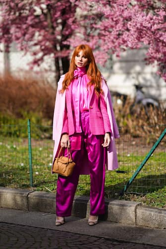 MILAN, ITALY - FEBRUARY 20: A guest wears a pink coat, a neon pink silky shiny lustrous shirt, a jacket, silky pants, a brown leather bag, pointy shoes, outside Koche x Pucci, during Milan Fashion Week Fall/Winter 2020-2021 on February 20, 2020 in Milan, Italy. (Photo by Edward Berthelot/Getty Images)