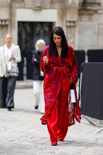 PARIS, FRANCE - MAY 03: A guest wears a red velvet embossed muslin kimono-style dress with a light purple inner lining, red damask wide leg pants, red pointy pumps, outside the Chanel Cruise Collection 2020  At Grand Palais on May 03, 2019 in Paris, France. (Photo by Edward Berthelot/Getty Images )