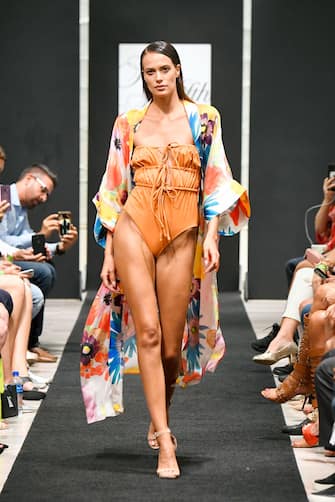MIAMI, FLORIDA - JULY 16: A model walks the runway wearing a Carolina K kimono and solid&striped swimsuit at Miami Swim Week Powered By Art Hearts Fashion Swim/Resort 2019/20 at Saks Fifth Avenue Brickell City Centre on July 16, 2019 in Miami, Florida. (Photo by Arun Nevader/Getty Images for Art Hearts Fashion)
