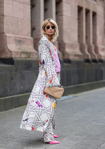 DUESSELDORF, GERMANY - AUGUST 5: Model and fashion blogger Gitta Banko wearing a kimono and silk trousers in Bauhaus-koi carp print pattern by Dawid Tomaszewski, a pink silk top from Jadicted, a Philo nude clutch made of calfskin by Lina Brax, pink suede Pigalle pumps by Christian Louboutin and Ray Ban sunglasses on August 5, 2017 in Duesseldorf, Germany. (Photo by Christian Vierig/Getty Images)