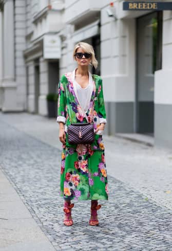 BERLIN, GERMANY - JULY 07: Model and fashion blogger Gitta Banko wearing a green floral-patterned kimono from Zara, a white t-shirt by James Perse, ankle-length jeans from Rag & Bone, Yuna sandals with braided strap details by Brain Atwood, black butterfly-shaped Le Debutante sunglasses from Le Specs, and a burgundy Classic Medium College Monogram leather bag by Saint Laurent during the Mercedes-Benz Fashion Week Berlin Spring/Summer 2018 on July 7, 2017 in Berlin, Germany. (Photo by Christian Vierig/Getty Images)