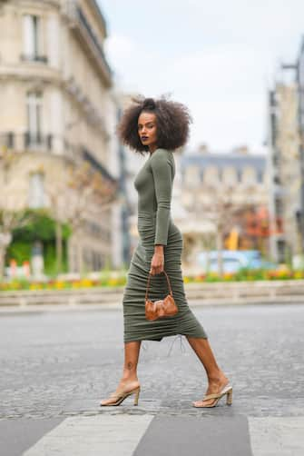 PARIS, FRANCE - APRIL 29: Alicia Aylies wears a green midi dress, a brown leather bag with crocodile pattern, beige sandals shoes, on April 29, 2021 in Paris, France. (Photo by Edward Berthelot/Getty Images)