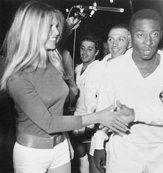 Soccer king Pele (right), of Brazil, and other team members meet French film star Brigitte Bardot at Colombes Stadium here March 31st during a charity match between the Santos of Brazil and combined French teams of St. Etienne and Marseille.
