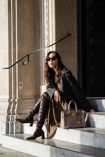 1294130627 PARIS, FRANCE - DECEMBER 20: Fashion blogger Xiayan wears sunglasses from Bottega Veneta, a black oversized blazer jacket from Les Coyotes de Paris, a brown gathered leopard print long dress from Les Coyotes de Paris, brown leather pointy boots from Charles & Keith, a Hermes Birkin beige leather bag, a golden necklace, on December 20, 2020 in Paris, France. (Photo by Edward Berthelot/Getty Images)