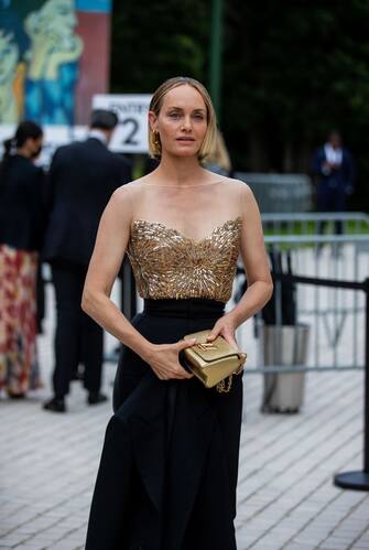PARIS, FRANCE - JULY 05: Amber Valletta is seen wearing golden off shoulder top, cropped pants, golden bag and boots outside Louis Vuitton Parfum Hosts Dinner at Fondation Louis Vuitton on July 05, 2021 in Paris, France. (Photo by Christian Vierig/Getty Images)