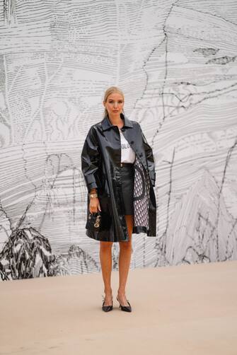 PARIS, FRANCE - JULY 05: Leonie Hanne wears a black shiny leather short trench coat, a white t-shirt from Dior "Revolution", a black leather short skirt, pointy pump shoes from Dior, outside Dior, during Paris Fashion Week - Haute Couture Fall/Winter 2021/2022, on July 05, 2021 in Paris, France. (Photo by Edward Berthelot/Getty Images)