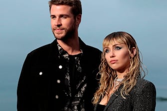 US singer Miley Cyrus and husband Australian actor Liam Hemsworth arrive for the Saint Laurent Men's Spring-Summer 2020 runway show in Malibu, California, on June 6, 2019. (Photo by Kyle GRILLOT / AFP)        (Photo credit should read KYLE GRILLOT/AFP via Getty Images)