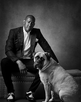 Dion Dublin with Bullmastiff Maggie. See SWNS story SWBRdogs. Celebrity portrait photographer Andy Gotts has created a series of stunning images of the UK's most famous faces - and their dogs. The world-renowned photographer has teamed up with Guide Dogs and its A-list supporters to shine a light on the stars’ most loyal fans. Simon Cowell, David Walliams, Tilda Swinton and Fiona Bruce were among the celebs who posed with their pooches to celebrate the charity’s 90th anniversary and help launch the 2021 Guide Dogs Appeal to fund life-changing services for people with sight loss. David Walliams, who was photographed with border terriers Bert and Ernie, said: “Guide Dogs is such an amazing charity and is one of the first charities you hear about as a child. 