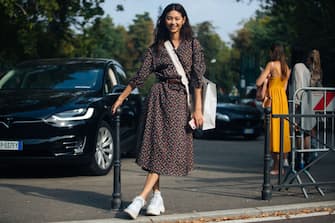 MILAN, ITALY - SEPTEMBER 22: Model Hoyeon Jung wears a floral dress, bellboy bag, and white sneakers during Milan Fashion Week Spring/Summer 2019 on September 22, 2018 in Milan, Italy.