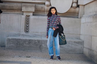 PARIS, FRANCE - SEPTEMBER 30: Model Hoyeon Jung wears a pink/purple print shirt, oversized blue jeans, a Chanel black leather bag, and red purple sneakers after the Poiret show during Paris Fashion Week Spring/Summer 2019 on September 30, 2018 in Paris, France. (Photo by Melodie Jeng/Getty Images)