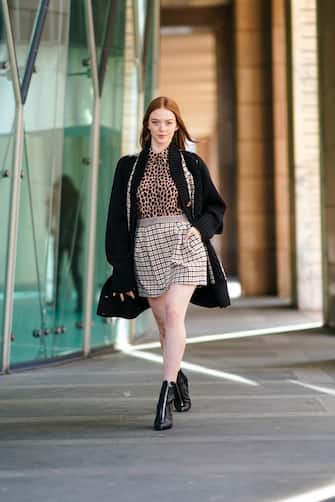 MILAN, ITALY - FEBRUARY 20: Larsen Thompson a black oversized wool jacket, a brown leopard print shirt, a checked skirt, black shiny pointy boots, outside Vivetta, during Milan Fashion Week Fall/Winter 2020-2021 on February 20, 2020 in Milan, Italy. (Photo by Edward Berthelot/Getty Images)