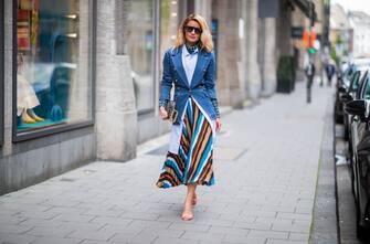 DUESSELDORF, GERMANY - MAY 05: Gitta Banko is seen wearing a layering look containing, a blue transparent turtleneck top with white dots, long oversize striped blouse and a multicolored pleated skirt by Steffen Schraut, a blue â  Diorquakeâ   clutch in oblique jacquard canvas by Dior, brown sunglasses by Escada and multicolored sandals by Sophia Webster on May 05, 2019 in Duesseldorf, Germany. (Photo by Christian Vierig/Getty Images)