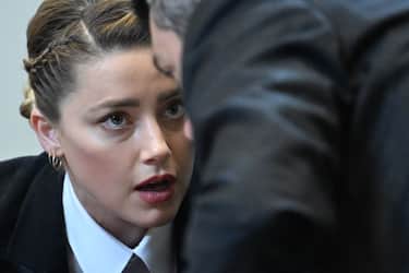 Actress Amber Heard speaks to her lawyer in the courtroom for the defamation trial against her at the Fairfax County Circuit Courthouse in Fairfax, Virginia, on May 3, 2022. - US actor Johnny Depp sued his ex-wife Amber Heard for libel in Fairfax County Circuit Court after she wrote an op-ed piece in The Washington Post in 2018 referring to herself as a "public figure representing domestic abuse." (Photo by JIM WATSON / POOL / AFP) (Photo by JIM WATSON/POOL/AFP via Getty Images)
