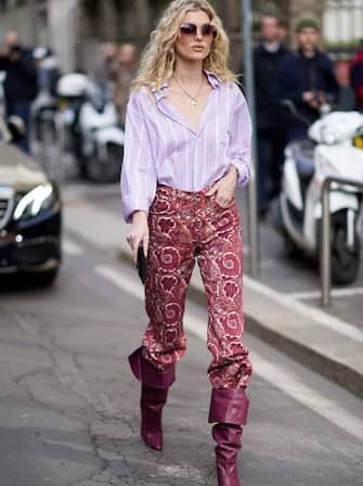 MILAN, ITALY - FEBRUARY 21: Romee Strijd wears a mauve pale purple shirt, a golden necklace, red pants with floral print, purple leather pointy boots, outside Etro, during Milan Fashion Week Fall/Winter 2020-2021 on February 21, 2020 in Milan, Italy. (Photo by Edward Berthelot/Getty Images)