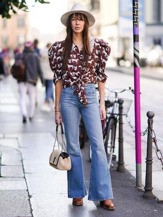 MILAN, ITALY - FEBRUARY 20: Estelle Chemouny wears a white hat, a ruffled puff shoulders brown shirt with printed horses, blue flare denim jeans pants, a Saint Laurent YSL bag, brown leather shoes, outside Koche x Pucci, during Milan Fashion Week Fall/Winter 2020-2021 on February 20, 2020 in Milan, Italy. (Photo by Edward Berthelot/Getty Images)