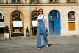 PARIS, FRANCE - MARCH 30: Natalia Verza @mascarada.paris wears a blue denim overall jumpsuit, a white polo shirt, a Louboutin mini bag, pointed high heels shoes from Louboutin, on March 30, 2021 in Paris, France. (Photo by Edward Berthelot/Getty Images)