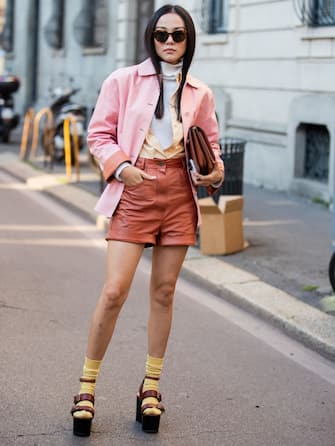 MILAN, ITALY - FEBRUARY 22: Yoyo Cao is seen wearing pink jacket, brown shorts, bag, turtleneck, platform sandals, yellow socks outside Ferragamo during Milan Fashion Week Fall/Winter 2020-2021 on February 22, 2020 in Milan, Italy. (Photo by Christian Vierig/Getty Images)