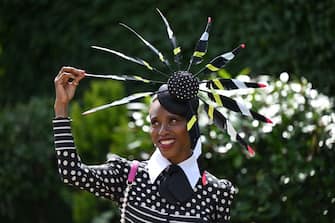 A race-goer wearing a hat poses upon her arrival to attend the thrid day, known as the Lady's day, of the Royal Ascot horse racing meet, in Ascot, west of London on June 16, 2022. (Photo by JUSTIN TALLIS / AFP ) (Photo by JUSTIN TALLIS / AFP via Getty Images)