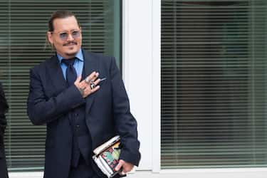 FAIRFAX, VA - MAY 27: (NY & NJ NEWSPAPERS OUT) Johnny Depp gestures to fans during a recess outside court during the Johnny Depp and Amber Heard civil trial at Fairfax County Circuit Court on May 27, 2022 in Fairfax, Virginia. Depp is seeking $50 million in alleged damages to his career over an op-ed Heard wrote in the Washington Post in 2018.(Photo by Cliff Owen/Consolidated News Pictures/Getty Images)