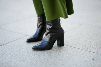 PARIS, FRANCE - OCTOBER 28: Alba Garavito Torre wears a dark green belted high waist midi skirt, black shiny leather crocodile print pattern block heels pointed ankle boots, during a street style fashion photo session, on October 28, 2021 in Paris, France. (Photo by Edward Berthelot/Getty Images)
