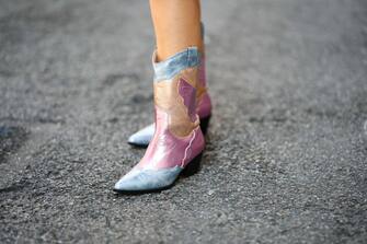 NEW YORK, NEW YORK - SEPTEMBER 14: Samia Laaboudi wears silver rings, blue / pink / gold shiny leather yoke with embroidered white pattern pointed / block heels knees boots , during New York Fashion Week, on September 14, 2022 in New York City. (Photo by Edward Berthelot/Getty Images)