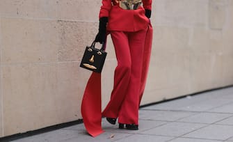 PARIS, FRANCE - OCTOBER 03: Denisa Palsha is seen wearing a Brandon Maxwell suit, a bag by Schiaparelli, a corset by Graham Cruz and a red LolaÂ´s hat, before the Stella McCartney Show during Paris Fashion Week on  October 03, 2022 in Paris, France. (Photo by Jeremy Moeller/Getty Images)