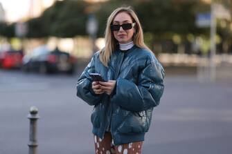 BERLIN, GERMANY - OCTOBER 07: Sonia Lyson is seen wearing brown Prada sunglasses, brown wool knit Prada sweater, white turtleneck Prada sweater, blue leather Rotate oversize bomber jacket and a brown print pattern pants from Rotate, on October 07, 2022 in Berlin, Germany. (Photo by Jeremy Moeller/Getty Images)
