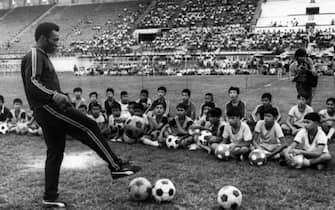(FILES) In this file photo taken on December 06, 1974 in Bangkok shows Brazilian football player Pelé during a training session with young boy as part of a commercial trip in Thailand.  - Brazilian football icon Pele, widely regarded as the greatest player of all time and a three-time World Cup winner who masterminded the 'beautiful game', died on December 29, 2022 at the age of 82, after battling kidney problems and colon cancer .  (Photo by AFP)