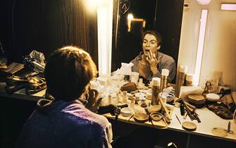 View of Russian-born ballet dancer and choreographer Rudolf Nureyev (1938 - 1993) in his dressing room, backstage at the Palais Garnier, Opera National de Paris, Paris, France, 1977. He was applying made up for an unspecified performance. (Photo by Derek Hudson/Getty Images)