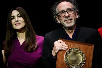 US director Tim Burton (R) reacts as he receives the Lumiere Award from Italian actress Monica Bellucci during the award ceremony of the 14th edition of the Lumiere Film Festival in Lyon, central-eastern France, on October 21, 2022. (Photo by JEFF PACHOUD / AFP) (Photo by JEFF PACHOUD/AFP via Getty Images)