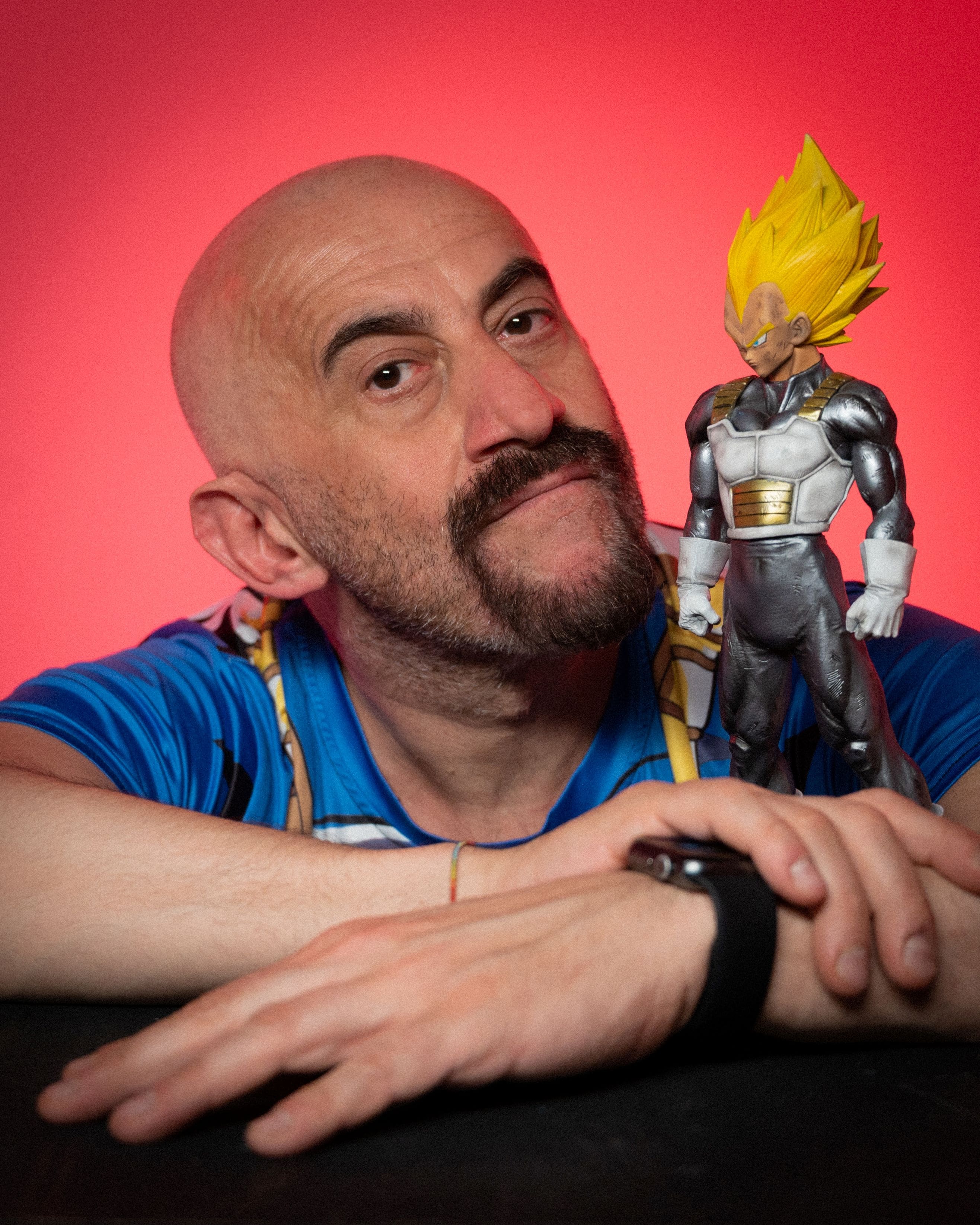 Il doppiatore Gianluca Iacono posa accanto a una action figure di Vegeta