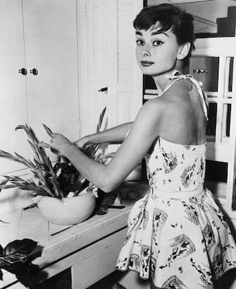 (Original Caption) 6/30/1954-New York, NY: Pixyish Audrey Hepburn, Academy Award actress, beats the Manhattan heat with a cool play suit as she does chores in her New York apartment. Miss Hepburn, who will soon be seen in the movie "Sabrina," leaves July 6th for a two month vacation in Holland, Switzerland and England.