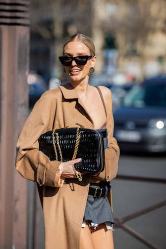 PARIS, FRANCE - MARCH 08: Leonie Hanne is seen wearing beige coat, grey cropped top, mini skirt, knee high socks, loafers, black bag outside Miu Miu during Paris Fashion Week - Womenswear F/W 2022-2023 on March 08, 2022 in Paris, France. (Photo by Christian Vierig/Getty Images)
