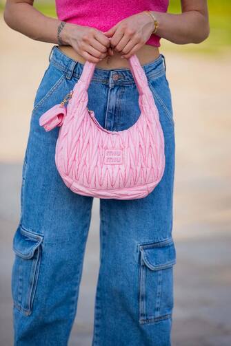 DUBAI, UNITED ARAB EMIRATES - APRIL 02: Lisa HahnbÃ¼ck is seen wearing pink cropped Jacquemus top polo, mango denim jeans with side pockets, rose Miu Miu bag & Amina Muaddi heels in white on April 02, 2022 in Dubai, United Arab Emirates. (Photo by Christian Vierig/Getty Images)