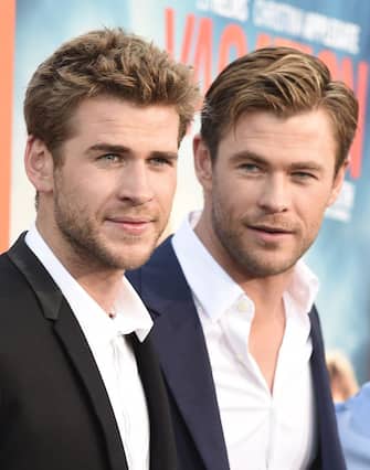 Actors Liam Hemsworth (L) and Chris Hemsworth arrive for the premiere of Warner Bros' "Vacation" at the Regency Village Theatre in Los Angeles on July 27, 2015. AFP PHOTO/ROBYN BECK        (Photo credit should read ROBYN BECK/AFP via Getty Images)
