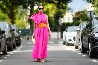 PARIS, FRANCE - AUGUST 02: Gabriella Berdugo wears eyecat sunglasses form Stella Mccartney, a Fuchsia neon pink nylon long turtleneck dress with couture pads shoulder pleated / gathered details, an orange maxi belt from Natan, neon pink sliders bejeweled sandals from Roger Vivier, a vintage vinyl beige long bag with embossed monograms from Louis Vuitton, on August 02, 2021 in Paris, France. (Photo by Edward Berthelot/Getty Images)