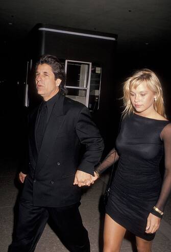 Producer Jon Peters and model Pamela Anderson attend the premiere of 'Glory' on December 11, 1989 at the Cineplex Odeon Cinema in Century City, California. (Photo by Ron Galella, Ltd./Ron Galella Collection via Getty Images)