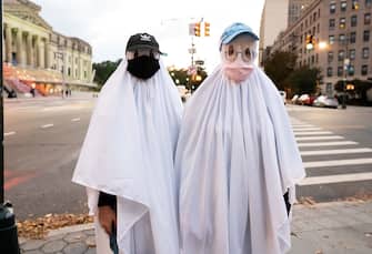 NEW YORK, NEW YORK - OCTOBER 31: People dressed as ghosts wear face masks outside the Brooklyn Museum on October 31, 2020 in New York City. Many Halloween events have been canceled or adjusted with additional safety measures due to the ongoing coronavirus (COVID-19) pandemic. (Photo by Noam Galai/Getty Images)