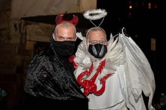 NEW YORK, NEW YORK - OCTOBER 31: A couple dressed as an angel and devil poses in the West Village on October 31, 2020 in New York City. Many Halloween events have been canceled or adjusted with additional safety measures due to the ongoing coronavirus (COVID-19) pandemic. (Photo by Alexi Rosenfeld/Getty Images)