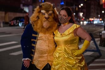 NEW YORK, NEW YORK - OCTOBER 31: People dressed as Beauty and the Beast pose the West Village on October 31, 2020 in New York City. Many Halloween events have been canceled or adjusted with additional safety measures due to the ongoing coronavirus (COVID-19) pandemic. (Photo by Alexi Rosenfeld/Getty Images)
