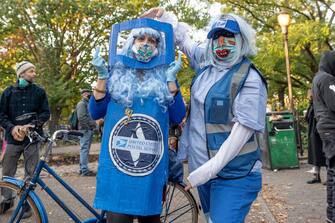 NEW YORK, NEW YORK - OCTOBER 31: Women dressed as a United States Postal Service mailbox and mail worker pose together in the East Village on October 31, 2020 in New York City. Many Halloween events have been canceled or adjusted with additional safety measures due to the ongoing coronavirus (COVID-19) pandemic. (Photo by Alexi Rosenfeld/Getty Images)