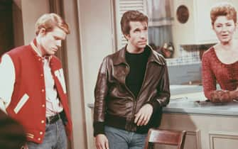 Left to right: American actors Henry Winkler, as Arthur 'Fonzie' Fonzarelli, Ron Howard as Richie Cunningham, and Marion Ross as Marion Cunningham, in a scene from the television sitcom 'Happy Days', circa 1975. (Photo by Fotos International/Hulton Archive/Getty Images)