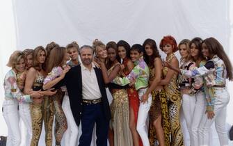 Gianni Versace poses with a group of models wearing his spring-summer collection in Milan, March 1991. (Photo by Vittoriano Rastelli/CORBIS/Corbis via Getty Images)