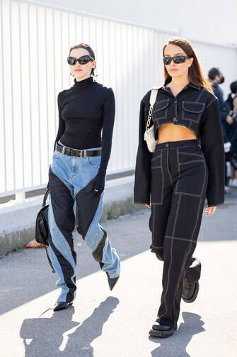 MILAN, ITALY - FEBRUARY 23: Burlaka Nastya (L) poses ahead of the Diesel fashion show wearing Mugler bicolor denim pants, black turtleneck and Balenciaga sunglasses during the Milan Fashion Week Fall/Winter 2022/2023 on February 23, 2022 in Milan, Italy. (Photo by Valentina Frugiuele/Getty Images)