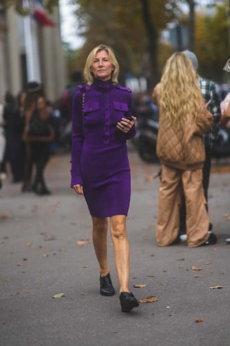 PARIS, FRANCE - OCTOBER 05: A guest wears a dark purple ribbed velvet long sleeves buttoned tube dress, a shoulder bag, silver rings, black shiny leather shoes, outside Miu Miu, during Paris Fashion Week - Womenswear Spring Summer 2022, on October 05, 2021 in Paris, France. (Photo by Edward Berthelot/Getty Images)